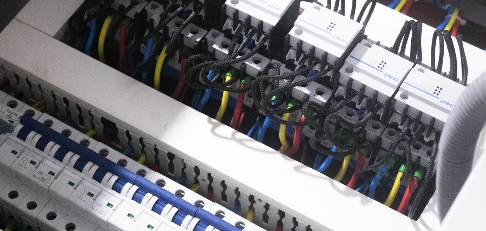 Elektriker von Elektro Müller verlegt Kabel in einem Schaltschrank